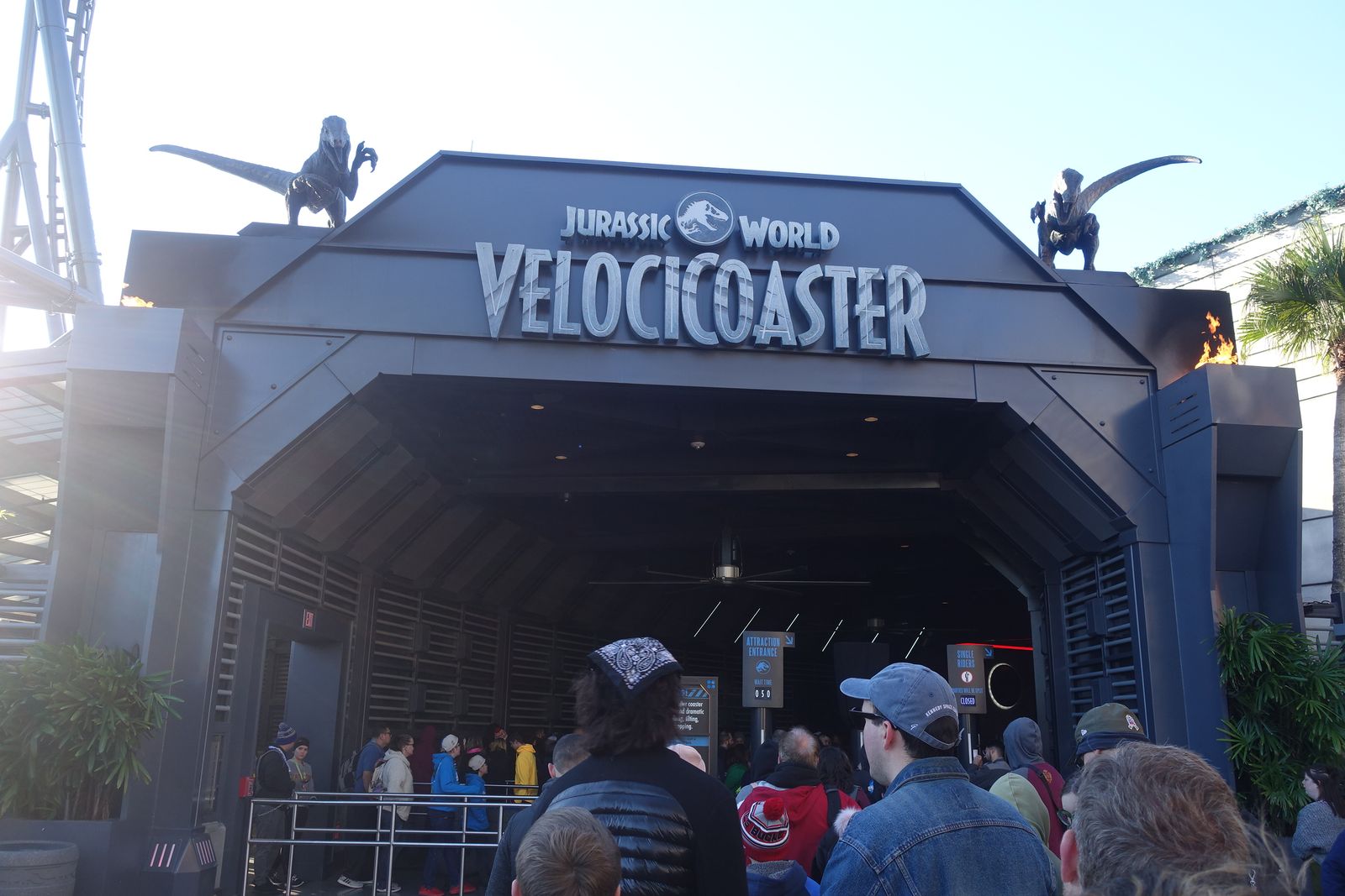 The Jurassic World VelociCoaster entrance sign with raptor statues at Universal's Islands of Adventure