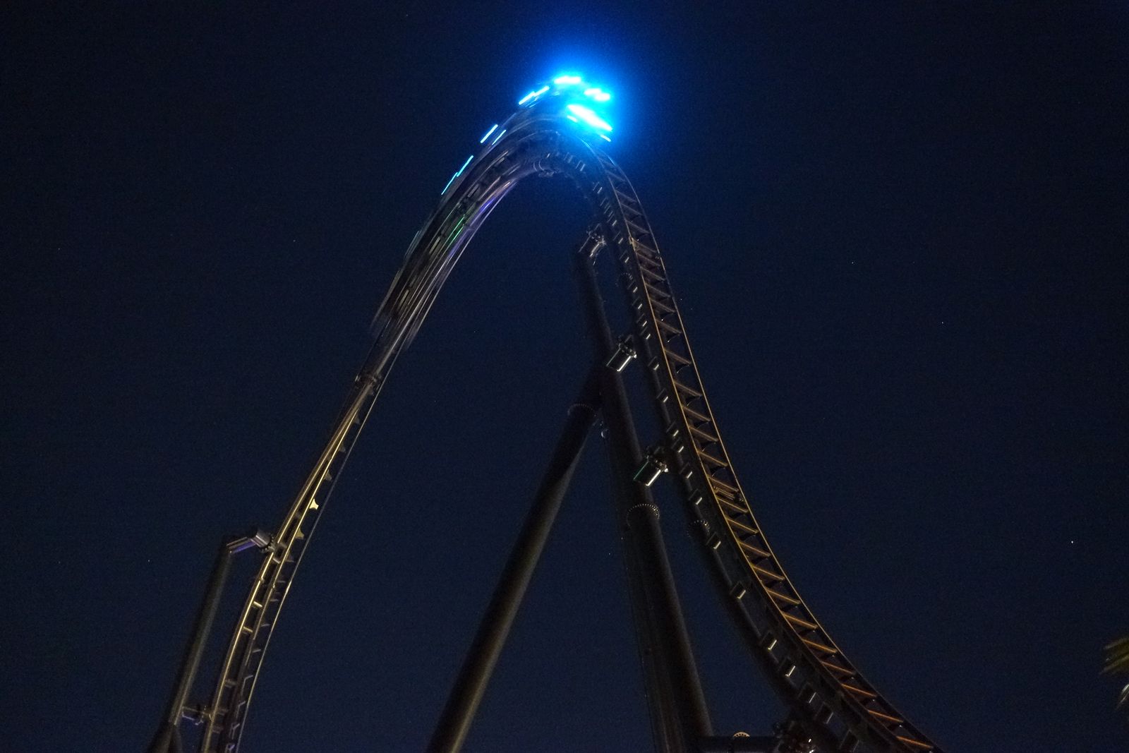 Jurassic World VelociCoaster track lit up at night at Islands of Adventure